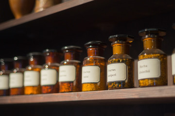 Vintage alchemy chemistry workshop rack shelf and glass vials ingredients - obrazy, fototapety, plakaty