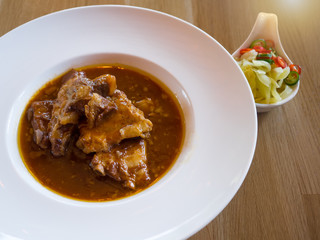 Close up Roast Spare Rib Pork with Tomato Sauce on wooden table.