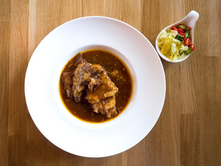 Roast Spare Rib Pork with Tomato Sauce on wooden table.