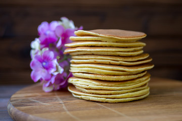 Tasty homemade pancakes with cream and raspberry. On wooden table. Village kitchen