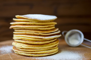 Tasty homemade pancakes with cream and raspberry. On wooden table. Village kitchen