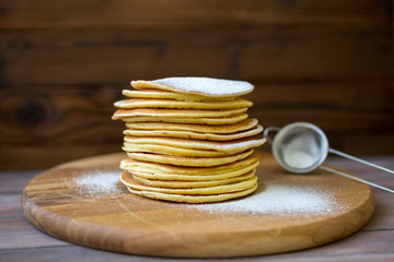 Tasty homemade pancakes with cream and raspberry. On wooden table. Village kitchen