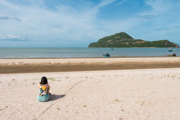 Fototapeta na wymiar a young woman is sitting on the beach