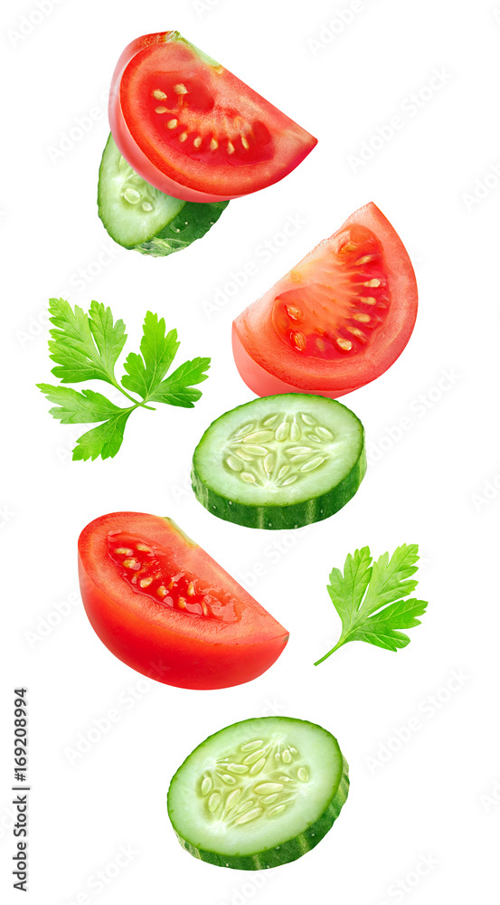 Poster Isolated vegetables. Mixed slices of cucumber and tomato floating in the air isolated on white with clipping path