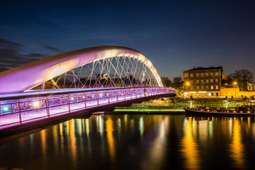 Fototapeta na wymiar Bernatka footbridge over Vistula river at night in Cracow, Poland