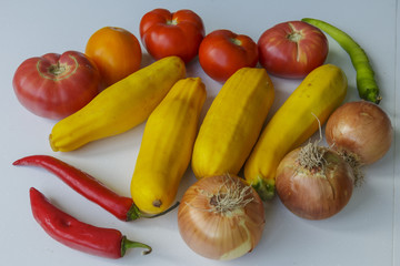 Vegan food. Yellow zucchini, Tomatoes, Onions and Hot Peppers isolated on white background