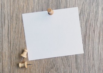 Pinned white note on wooden board