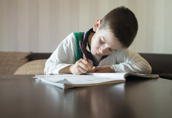 Child do his homework. Hand hold pen. Boy learning