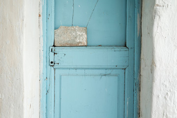 Old house with vintage wooden blue cyan door and white wall