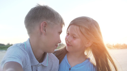 Fototapeta premium Closeup of blonde little brother and sister taking selfie together