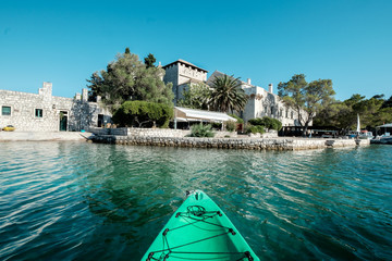 Kayaking on a boat on a beautiful sea lake in mediterranean Croatia with a view of a nice old dominican monastery of Saint Mary