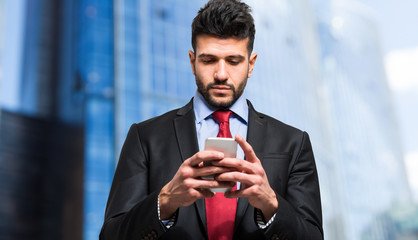 Businessman typing sms on his smartphone