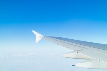 Fototapeta na wymiar Airplane wing above cloud seen through window