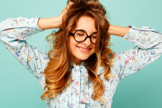 Pretty smiley girl wearing glasses over blue background
