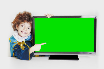 Cute curly red-haired prince points his index finger on a green screen set. Close-up. Gray background.