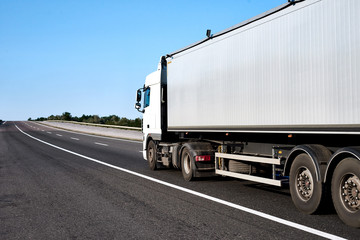 Truck on road with blank container, cargo transportation concept