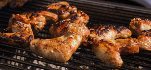 several pieces of roasted chicken wings on a barbecue