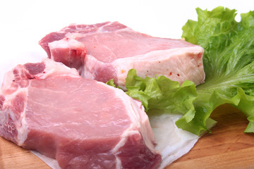Raw pork chops with herbs and spices on cutting board. Ready for cooking.