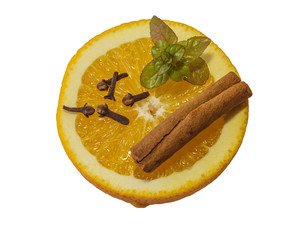 half of fresh orange with cinnamon cloves and mint leves isolated on white background