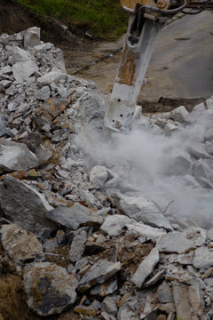 hammer drill demolishing old bridge, dust, stones and bricks  all over the place, 