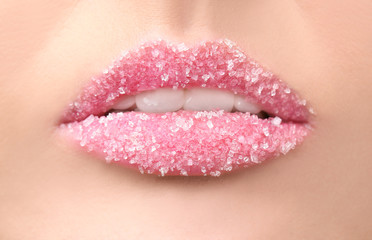 Lips of beautiful young woman covered with sugar, closeup