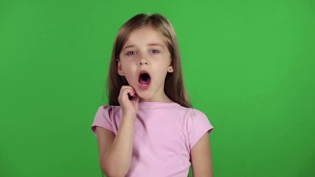 Little girl yawns. Green screen. Slow motion