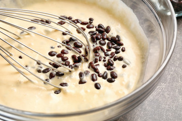 Bowl with raw dough and chocolate dragee, closeup