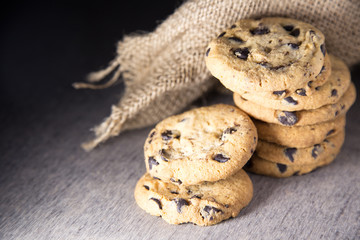 Chocolate chip cookies on linen napkin on wooden table.