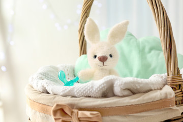 Cute knitted toy bunny in wicker basket