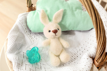 Cute knitted toy bunny in wicker basket