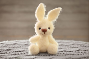 Obraz premium Knitted toy bunny on blurred background