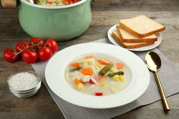 Plate with delicious turkey soup on table