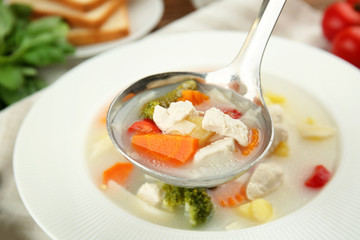 Plate with delicious turkey soup on table