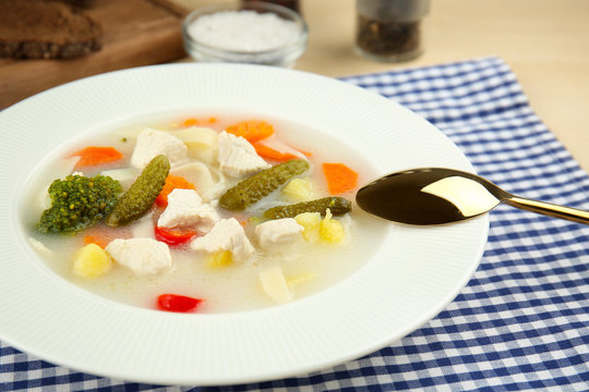 Plate with delicious turkey soup on table