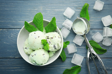 Composition with delicious mint chocolate chip ice cream and ice cubes on wooden table