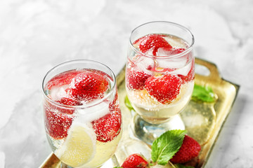 Tray with glasses of delicious strawberry lemonade on light table