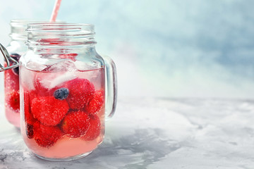 Jar with delicious strawberry lemonade on light table
