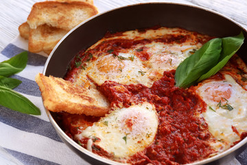 Frying pan with eggs in purgatory on table