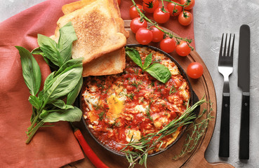 Frying pan with eggs in purgatory on table