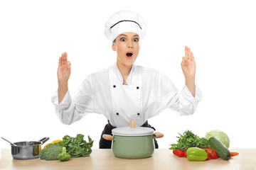 Young female chef near table with different products, on white background