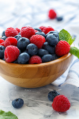 Blueberry and raspberry in wooden bowl.