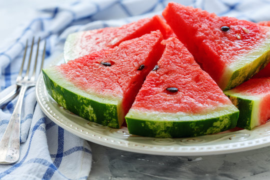 Juicy watermelon slices on a porcelain dish.