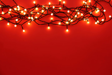 Christmas lights glowing on red background