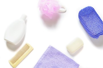Natural organic bath products/ Shampoo bottle, hair brush, pink and purple sponge puff, soap and cotton towel on a white background. Mockup, free space for text. Flat lay photography, top view