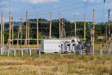 electric substation standing on the grass among trees