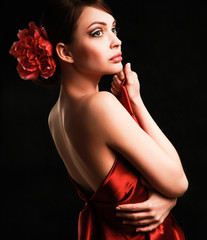 Young woman in red dress, isolated on black background