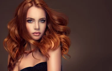 Photo sur Plexiglas Salon de coiffure Belle fille modèle avec de longs cheveux bouclés rouges. Tête rouge. Produits de soins, coloration des cheveux.