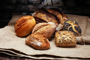 Different kinds of bread and bread rolls on wooden table