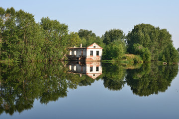 The ruins of the old houses on the river bank reflected in the water