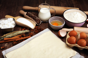 Bakery ingredients - flour, eggs, butter, sugar, yolk, almond nuts on blue table. Sweet pastry baking concept.